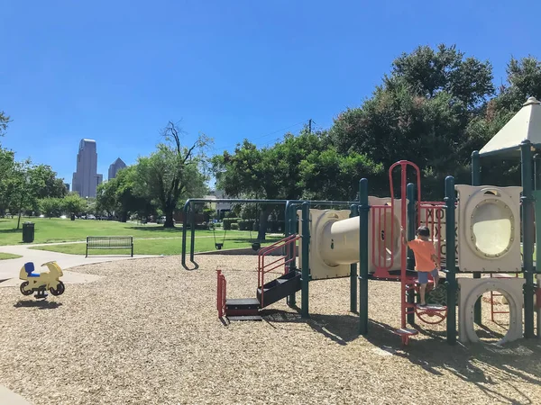 Parque infantil vacío rodeado de grandes árboles con rascacielos en el centro de Dallas, Texas, EE.UU. — Foto de Stock