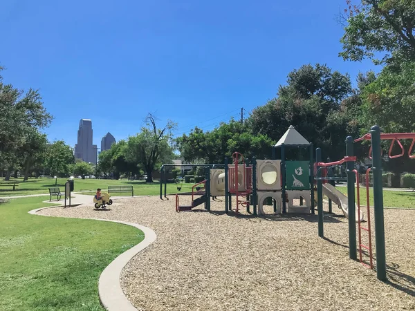 Parque infantil vacío rodeado de grandes árboles con rascacielos en el centro de Dallas, Texas, EE.UU. — Foto de Stock