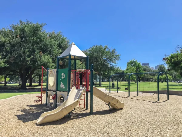 Parque infantil urbano en parque público rodeado de grandes árboles en el centro de Dallas, Texas, EE.UU. — Foto de Stock