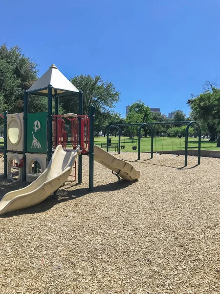 Міський дитячий майданчик у громадському парку, оточений великими деревами в центрі Далласа, штат Техас, США. — стокове фото