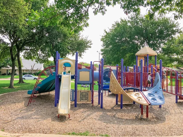 Variedad de tobogán y columpio en Colorido parque infantil cerca de barrio residencial en Richardson, Texas, EE.UU. — Foto de Stock