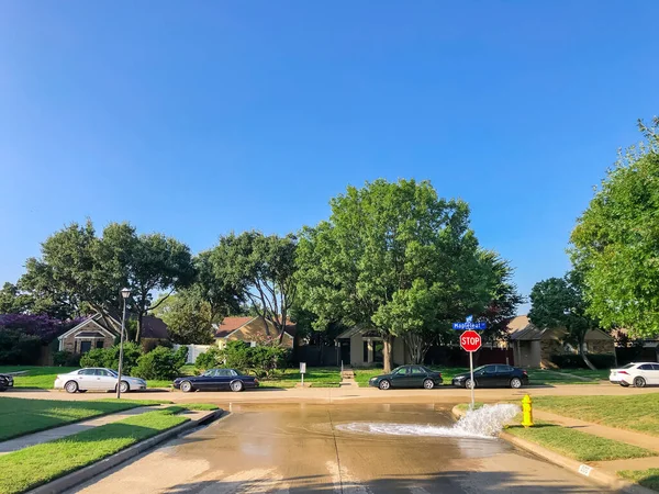 Test idrante giallo acqua zampillante attraverso una strada residenziale vicino Dallas, Texas, Stati Uniti d'America — Foto Stock