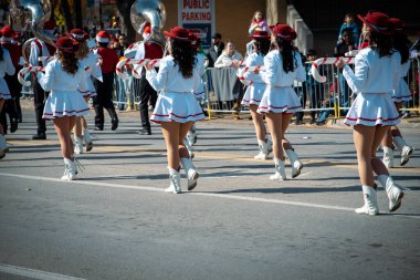 İzleyiciler, aralarında barikatların arkasından gelen çocukların da bulunduğu, beyaz etekli Noel gösterilerini izleyen, kırmızı şapkalıların şeker kamışı aksesuarları taşıyan, neşeli şehir bayramını izleyen ebeveyn omuzlarına odaklanıyorlar. ABD