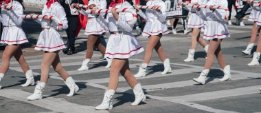 Panorama manzaralı, beyaz etekli ve kırmızı aksanlı üniformalı oyuncular diğer kırmızı kostümlü, sıradan giyinen katılımcılarla birlikte yürüyorlar. Banner, Dallas, TX 'teki grup farklılığı birliğini ön plana çıkardı. ABD