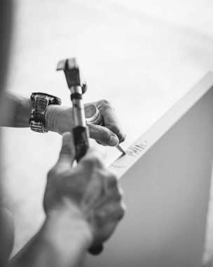 Asyalı el yapımı pençe çekici, akıllı spor saat, zanaatkar beyaz kapı levhası mort menteşe yontuyor, geleneksel el aletlerini modern takılabilir teknolojik tamir anlarıyla harmanlıyor. ABD