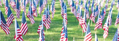 Panorama view top down view single flag casts long shadow across grass, evoking legacy and quiet dignity in Coppell 9/11 tribute, where memory stretches beyond the moment, suburbs Dallas, Texas. USA