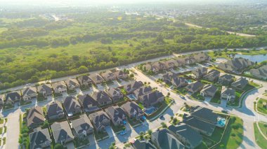 Yerel otoyol FM 407, Lantana, Teksas 'taki göletli yeni gelişmekte olan banliyö evlerini yemyeşil kuşaktan ayırıyor. Usta tarafından planlanan toplumlarda geçiş bölgelerinin ve gelişimin altını çiziyor. ABD