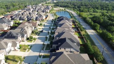 Local highway FM 407 separates new development suburban homes with pond in Lantana, Texas from a lush greenbelt vacant land. Highlights transitional zoning and edge development planning, flyover