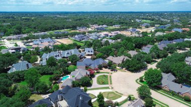 Aerial view active construction sites of luxury mansion homes in Colleyville, Texas, oversized lot with exposed framing, timber structure, tile roofs, landscaped yards in growing upscale suburbs. USA