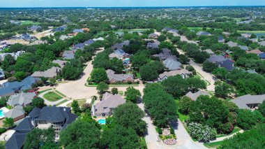 Water front suburban houses, mansion home with active construction in Colleyville, Texas, circular cul-de-sac, tree-lined streets, backyard pools, manicured lawns in growing affluent suburbs. USA