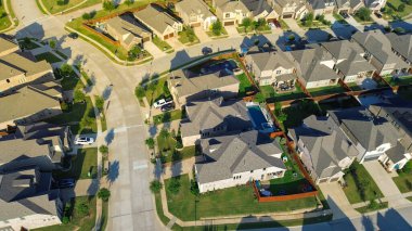 Lantana, Teksas 'taki üniformalı banliyö tasarımı kiremitli çatıları, çitli bahçeleri ve geniş temiz kaldırımlı caddeleri olan tuğla evler gösteriyor. Bahçe düzenlemesi Dallas 'ın banliyölerinde HOA tarafından yönetilen bir alanı yansıtıyor. ABD