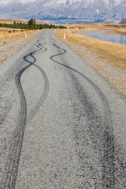 asphalt road with black rubber tyre skid marks - dangerous driving concept clipart