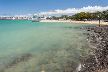 Auckland, Yeni Zelanda - 9 Aralık 2012: Arka planda Auckland silueti ile Devonport kumlu plaj