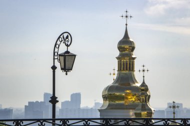 Kiev Pechersk Lavra topraklarında bir katedrallerin kubbe. Sabah sis şehir arka planda, ve ön planda fener