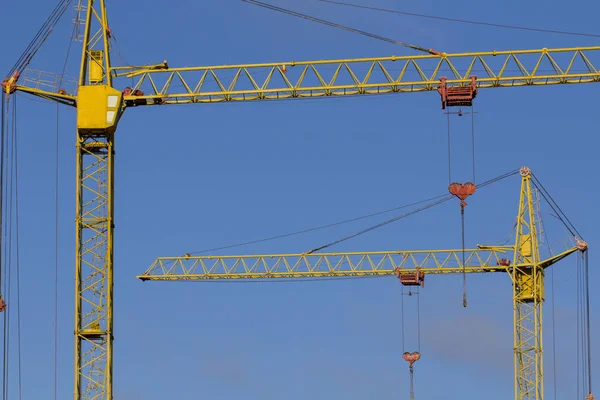 Turmdrehkran gegen den blauen Himmel, der Prozess des Baus eines mehrstöckigen Gebäudes — Stockfoto