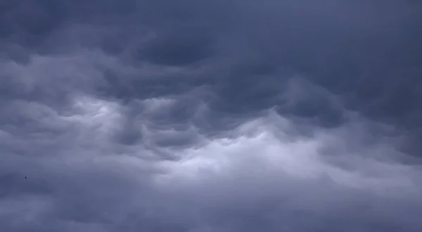 Свет в темноте и драматичные грозовые облака на фоне — стоковое фото