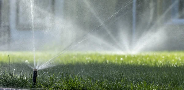 Système d'arrosage automatique arrosage de la pelouse sur un fond d'herbe verte — Photo