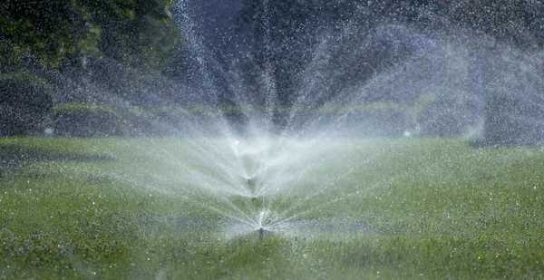 Système d'arrosage automatique arrosage de la pelouse sur un fond d'herbe verte — Photo