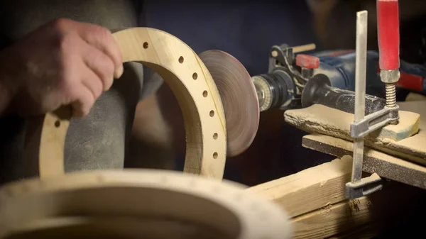 A large plan, hands of an artisan working on a wooden part — Stock Photo, Image