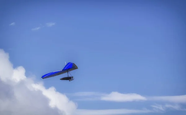 Planeador colgante volando en el cielo en un soleado día azul brillante —  Fotos de Stock