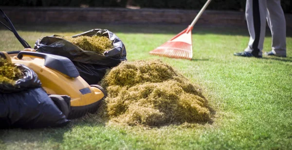 Bir Adam Keçe Ile Kırmızı Plastik Paçavra Bir Çim Havalandırma — Stok fotoğraf