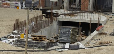 İnşaat alanında. İnşaat vinçleri ve yüksek katlı bina inşaat mavi gökyüzü altında.