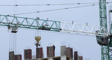 İnşaat alanında. İnşaat vinçleri ve yüksek katlı bina inşaat mavi gökyüzü altında.