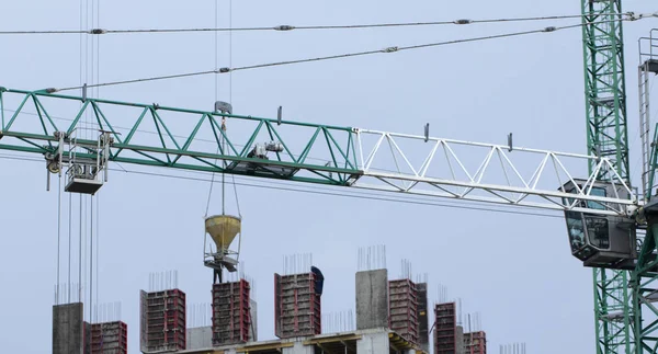 İnşaat alanında. İnşaat vinçleri ve yüksek katlı bina inşaat mavi gökyüzü altında.