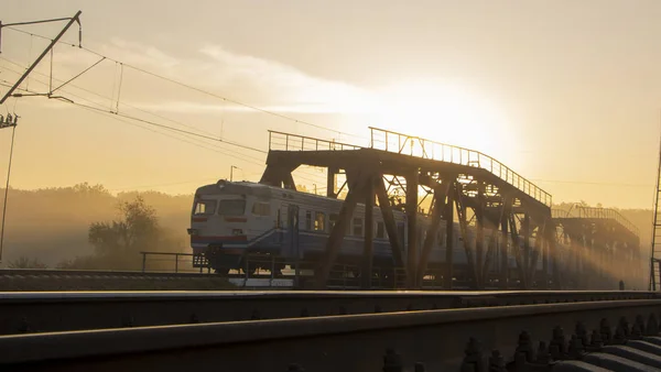 通りが霧の場合 早朝に電車に乗っている鉄道橋 — ストック写真