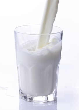 bir bardak süt beyaz bir arka plan üzerinde sıçrama oluşturma dökme yakın çekim