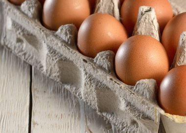 Beyaz masa karton raf veya yumurta kutusunda tavuk yumurtası. Üstten görünüm.