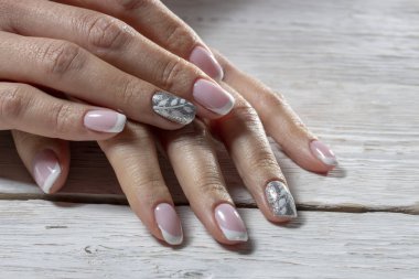 Manikür, izole bir beyaz ahşap arka plan üzerinde beyaz renk ile pembe yakın çekim