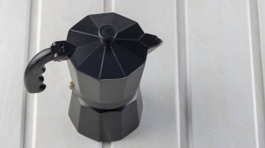 Beyaz ahşap arka plan en iyi manzaralı üzerinde İtalyan siyah kahve makinesi