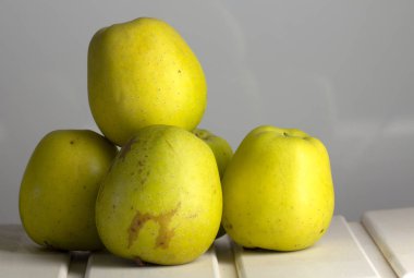 Bir raf üzerinde birçok yeşil elma. Beyaz, ahşap arka plan. Yakın çekim