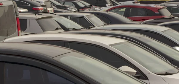 Many cars in the parking lot near the mall Close up