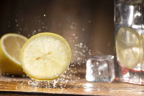 Plátek Citronu Dřevěný Stůl Stříkající Vodou Zblízka — Stock fotografie