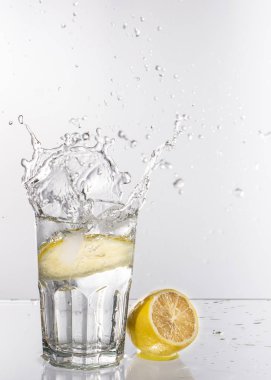 Bir bardak su ile hafif bir arka plan üzerinde limonata