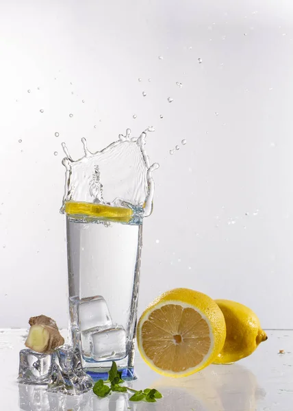 Sklenici limonády na světlém pozadí s šplouchání vody — Stock fotografie