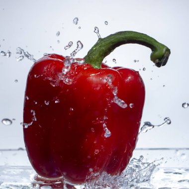 Tatlı biber damla su su beyaz zemin üzerine kırmızı biber sıçrama, yakın çekim