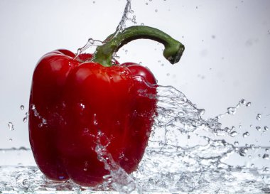 Tatlı biber damla su su beyaz zemin üzerine kırmızı biber sıçrama, yakın çekim