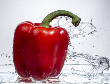 Tatlı biber damla su su beyaz zemin üzerine kırmızı biber sıçrama, yakın çekim