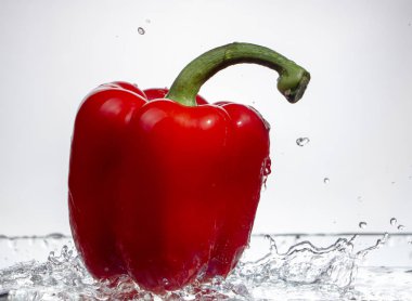 Tatlı biber damla su su beyaz zemin üzerine kırmızı biber sıçrama, yakın çekim