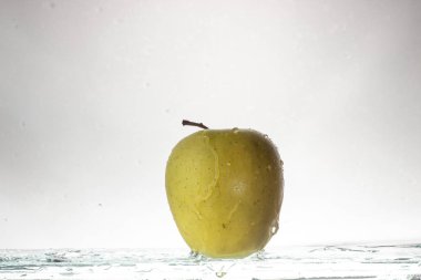 Açık renkli ve sıçramasına su yeşil elma yakın çekim