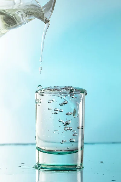 Pure water is poured into a glass beaker. close up