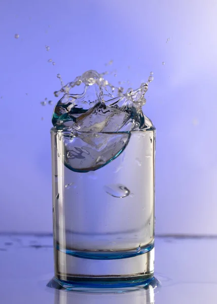Reines Trinkwasser Mit Spritzern Einem Runden Glas Auf Hellviolettem Hintergrund — Stockfoto