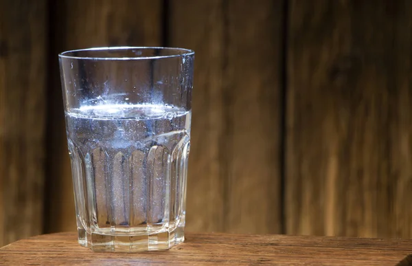 Glas Wasser Auf Einem Holztisch Vor Dem Hintergrund Einer Holzwand — Stockfoto