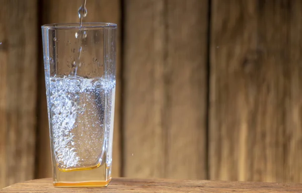 Glas Wasser Auf Einem Holztisch Vor Dem Hintergrund Einer Holzwand — Stockfoto