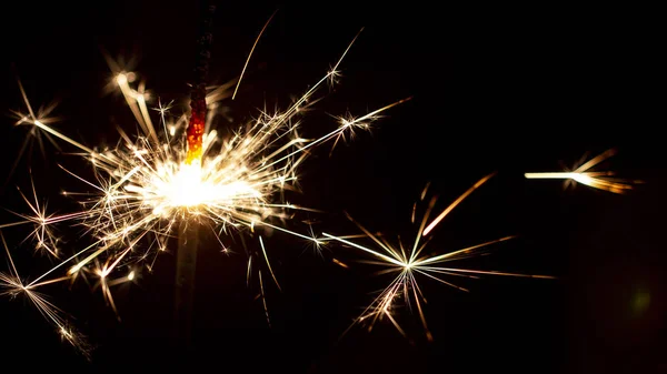 クリスマスの線香花火が黒い背景に分離されました ベンガルの火をクローズ アップ ストック写真