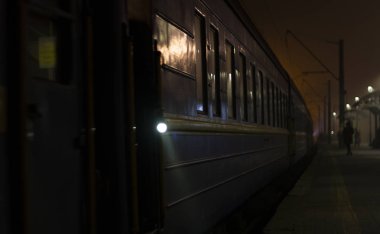 Tren Platformu geceleri geliyor. Parlak ışık ışınlarının karanlık dağıtmak. Arka plan