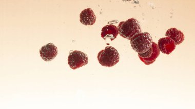 Ahududu meyve su portakal pastel arka planda sıçrama yapma yakın çekim